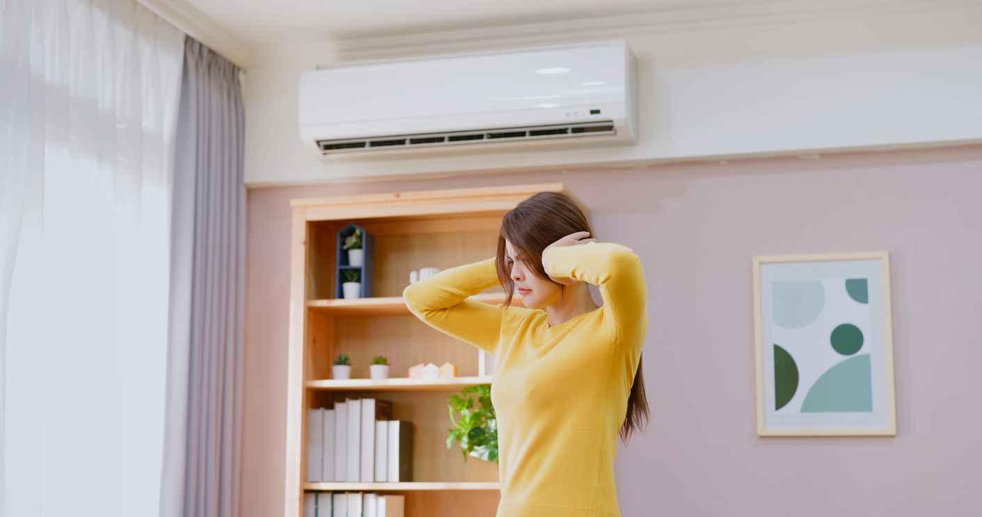 woman feel annoyed and she is suffering noise from heating or ac at home - trying covering her ears
