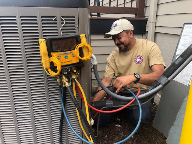 Technician performing AC maintenance