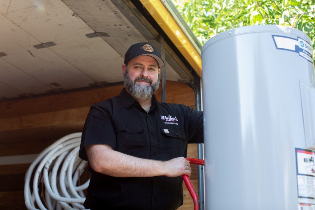 Wolfer's plumbing technician installing a water heater.