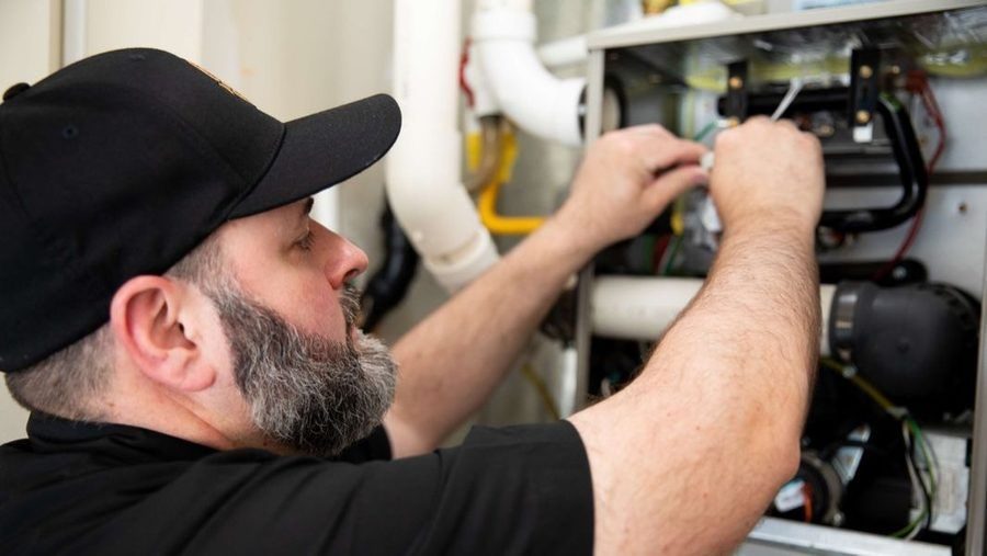 HVAC technician replacing furnace.